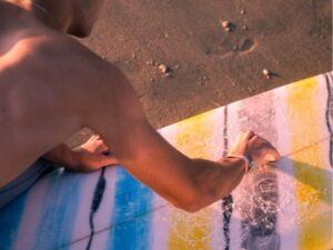 Man applying surf wax to a surfboard in Cape Town